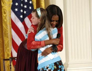 Una niña entrega a Michelle Obama el currículum de su padre en paro